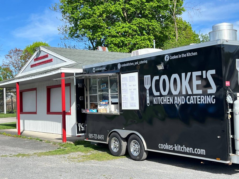 Cooke's Kitchen and Catering food truck serving with its window open on a sunny day at Canandaigua Baseball