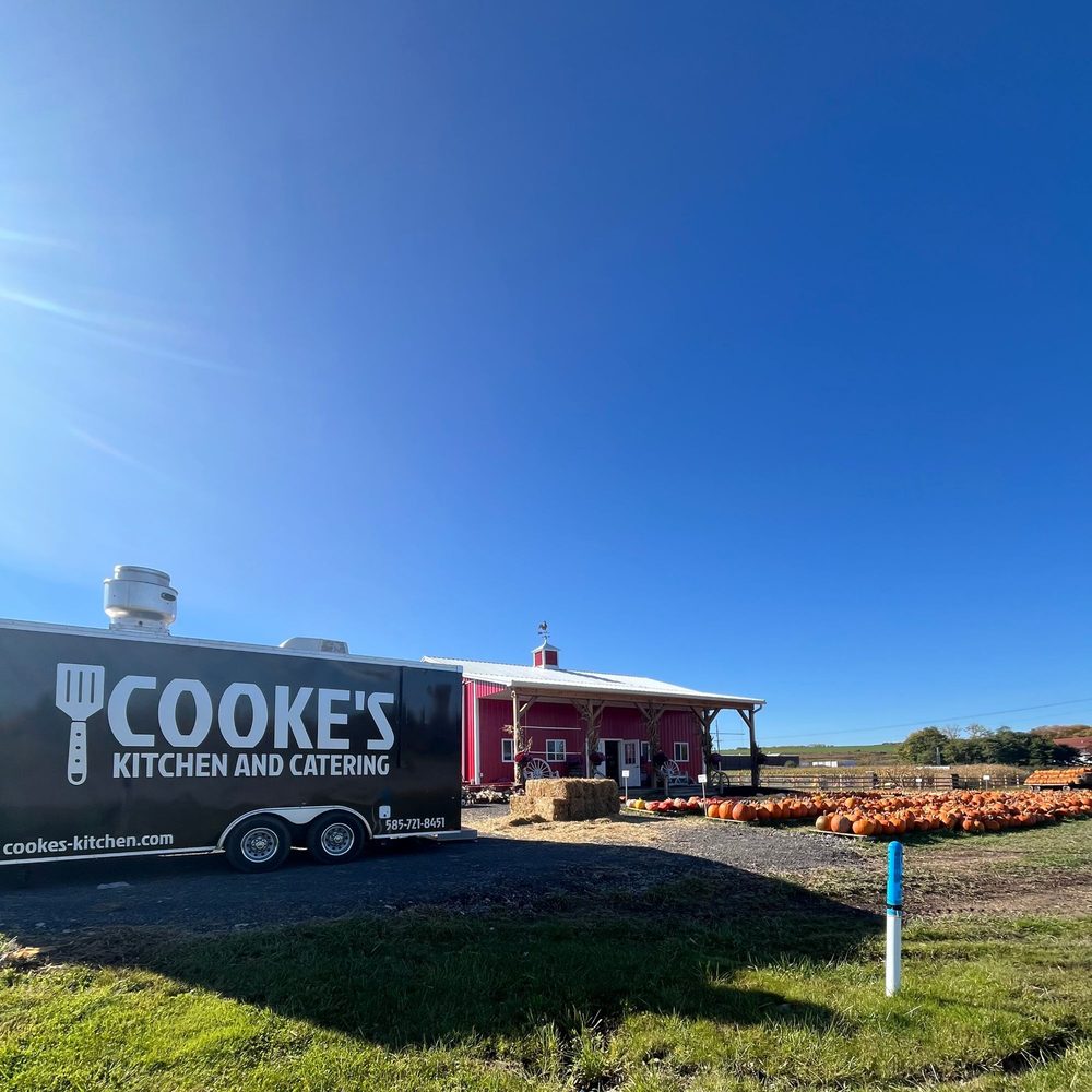 Cooke's Kitchen and Catering food truck parked at Duvall Farms with a red barn and pumpkins
