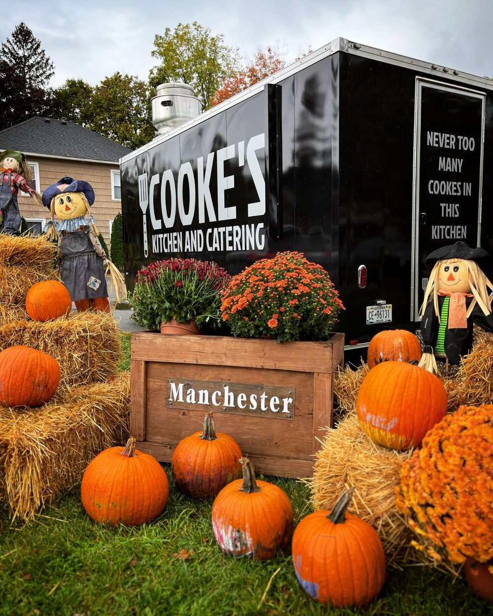 Cooke's Kitchen and Catering food truck surrounded by pumpkins and scarecrows at the Fall Festival in Manchester