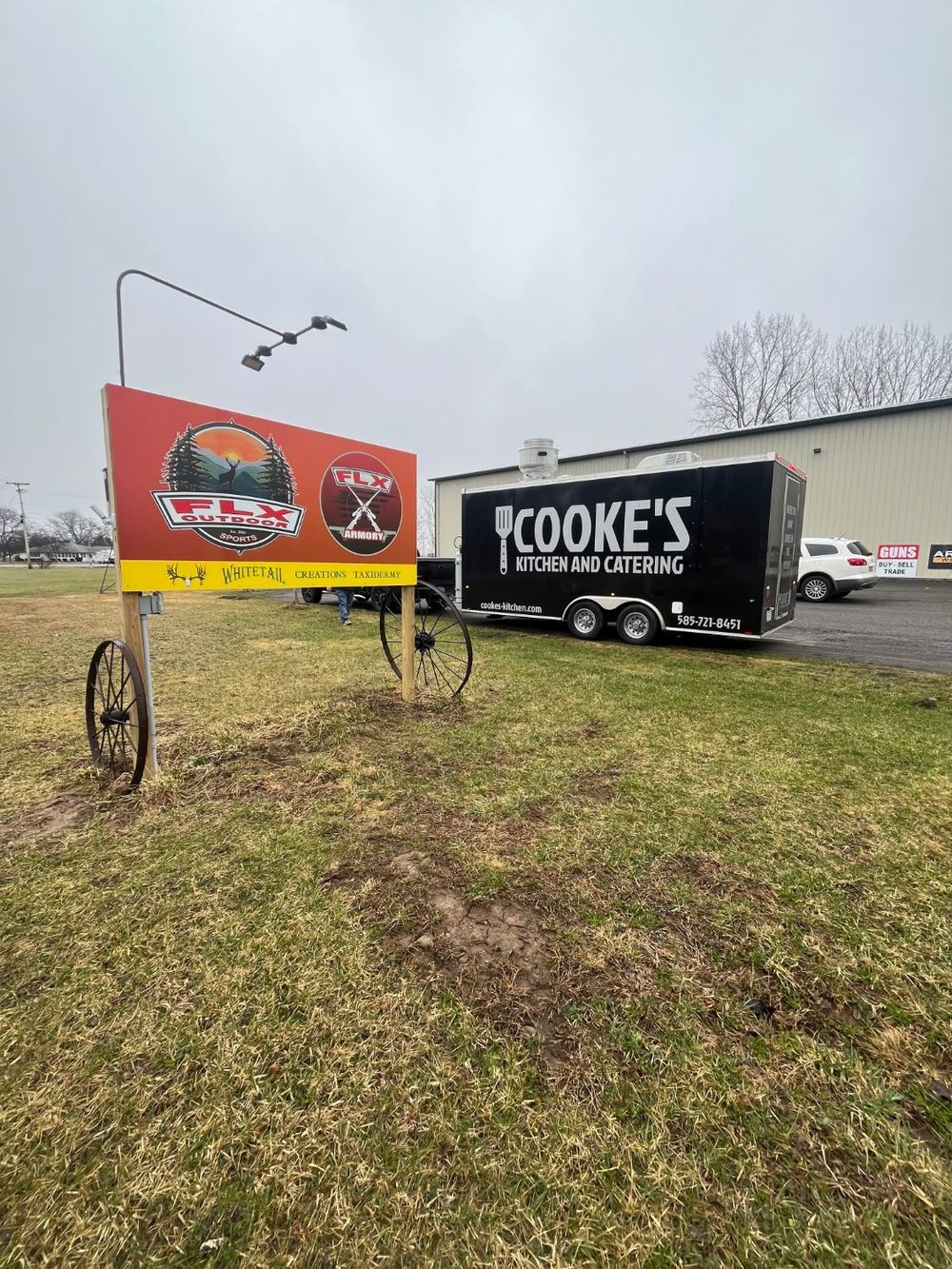Cooke's Kitchen and Catering food truck parked next to the FLX Outdoor Sports and Armory sign