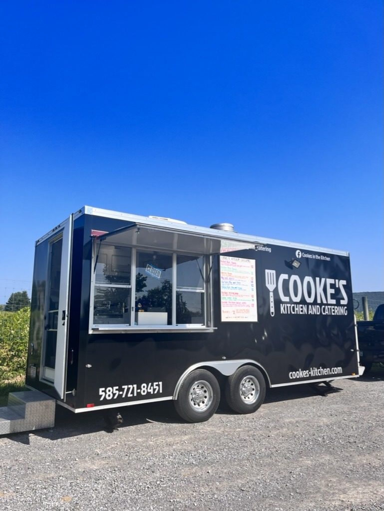 Cooke's Kitchen and Catering food truck parked on a sunny day with the menu posted in the window